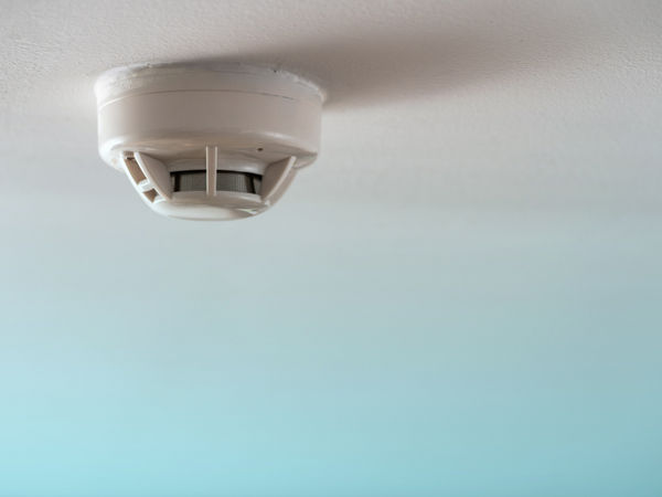 white and gray smoke detector in a blue background