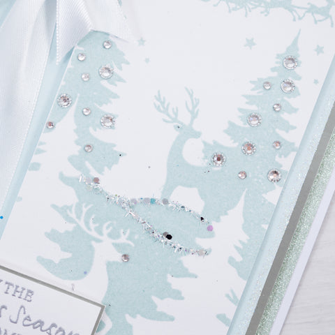 Learn how to make your own Christmas cards at home by following this free step-by-step tutorial from Chloes Creative Cards showing you how to make this icy blue and white reindeer winter wonderland scene.