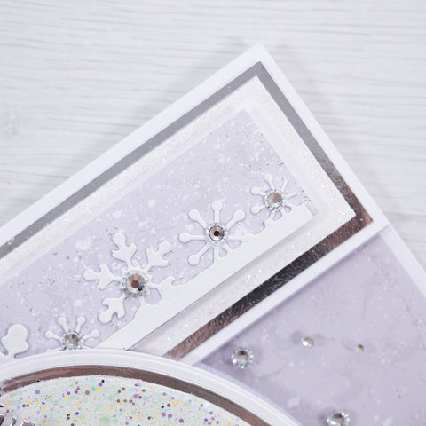 Our free Winter Wishes card making tutorial shows you step-by-step how to make this gorgeous silver mirror card Christmas Tree stamp featuring lovely lilac and white card layers with glitter snowflake details