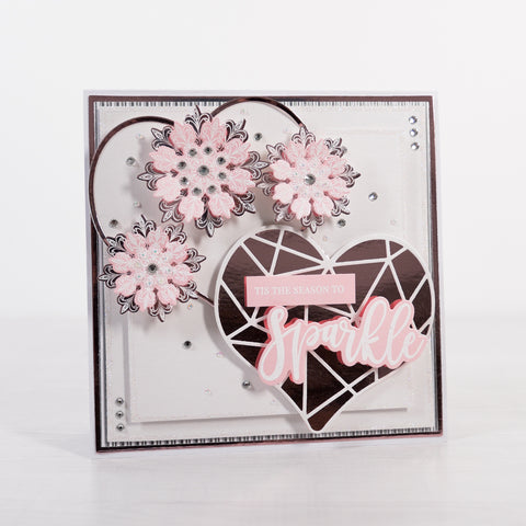 Learn how to create this pretty pink and rose gold heart Christmas Card featuring heart shaped layers and 3D paper snowflakes from Chloes Creative Cards.