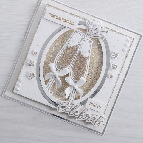 Learn how to make your own Champagne Glasses congratulations greetings card using our free card-making tutorial which is perfect for engagements, new jobs or promotions. This stunning white and gold card features glitter embellishment, script font sentiment stamps and beautiful bow details on our new champagne glasses.