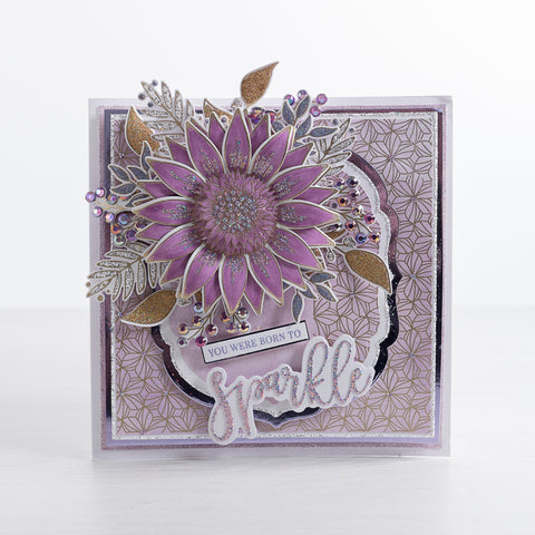 Learn how to create this bright pink and purple 3D flower card filled with glitter and sparkle using our free step-by-step card-making tutorial from Chloes Creative Cards. This tutorial features our new Geometric Flower background stamp as well as the 3D Summer Foliage stamp and Grande Sunflower Stamps.