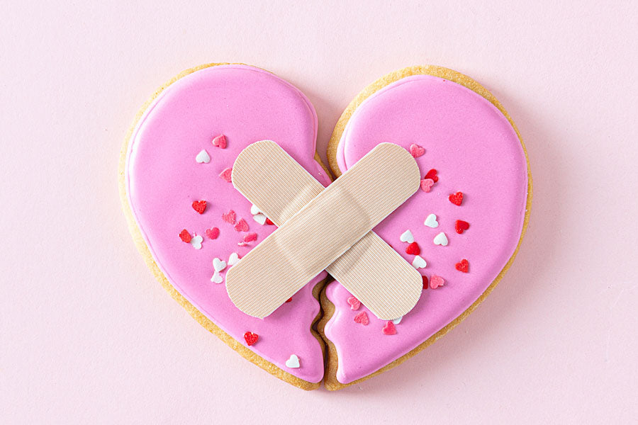 pink heart cookie broken with bandaids