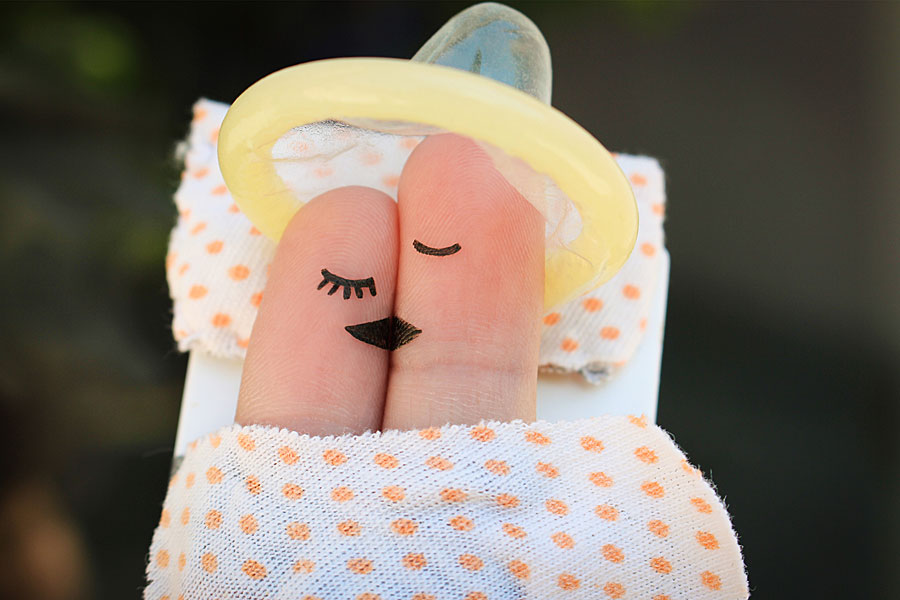 Mattress with finger puppet couple kissing and condom on their heads