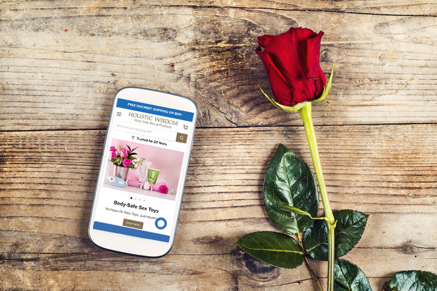 Cell phone on wooden table with rose