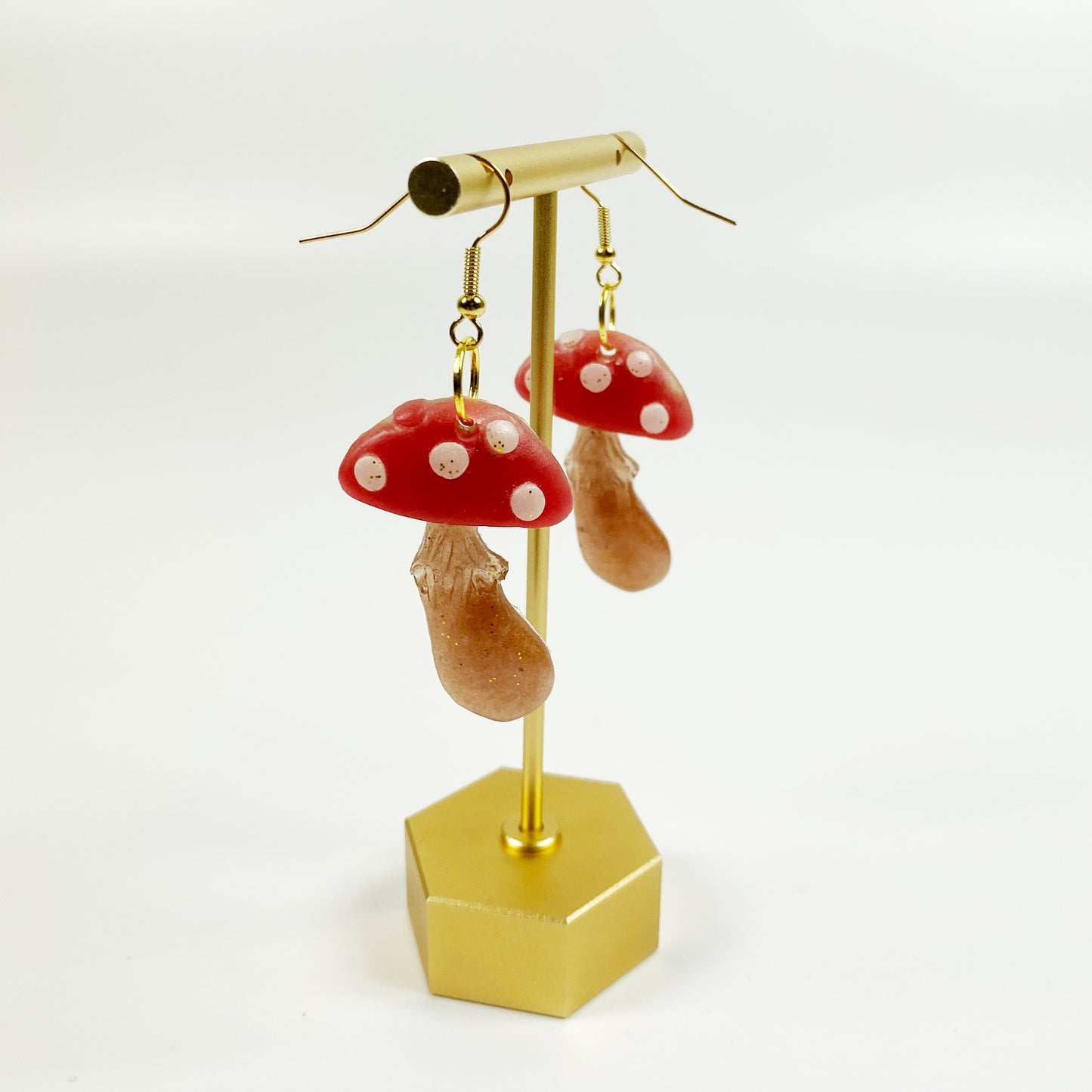 Adorable Mushroom Resin Dangle Earrings on brass display stand
