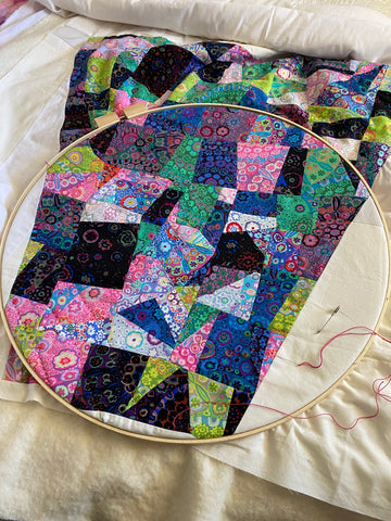 hand quilting in a large, circle wooden frame