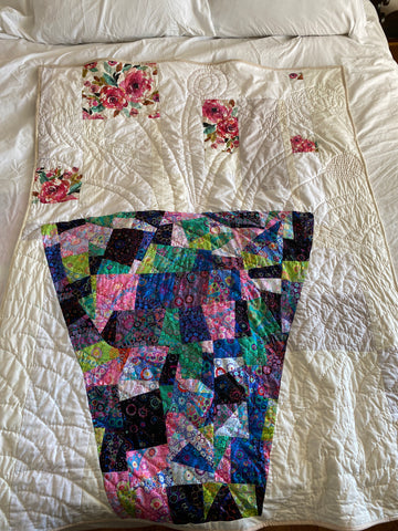 a quilt with a vase and flowers sewn out of fabric