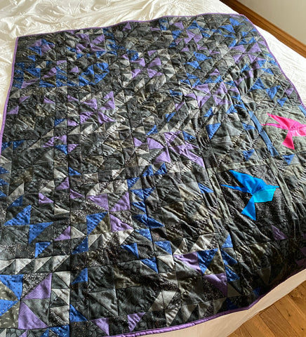 Out of Darkness lap quilt, two birds flying upward out of the darkness