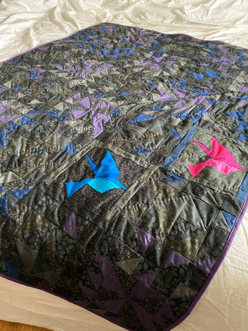 Out of Darkness lap quilt, two birds flying upward out of the black on black fabrics