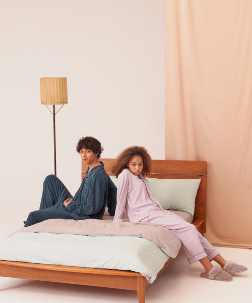 ベッドの上カップルがFoo Tokyoコットンパジャマを着ている