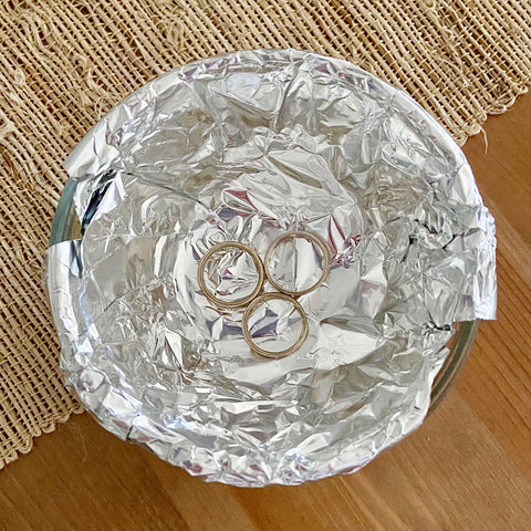 Sterling silver rings in a bowl lined with aluminum foil