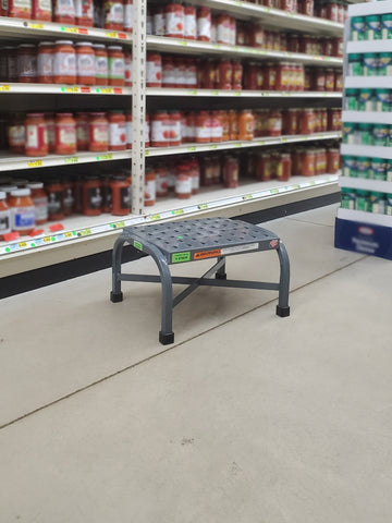 Heavy duty step stool in grocery store aisle next to pasta sauce