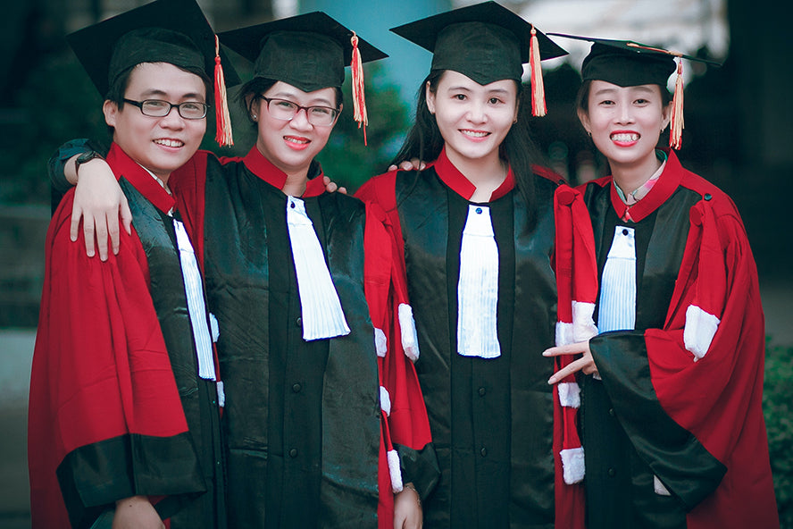 A group of four women posing for a graduation photo.