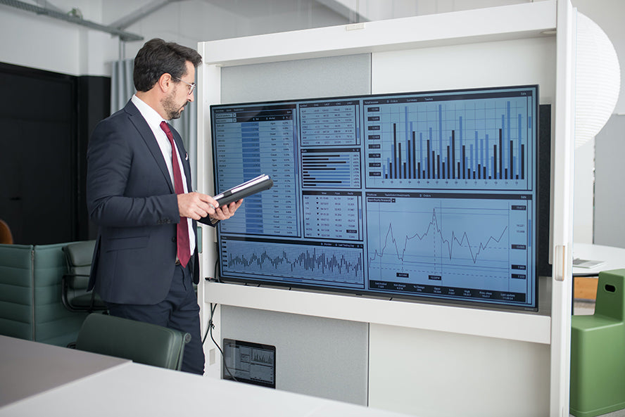 A man staring at large data displays while making important decisions.