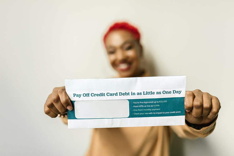 A woman smiling holding up a financial letter to the camera.