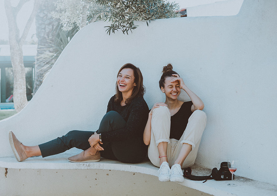 Two friends laughing with each other.