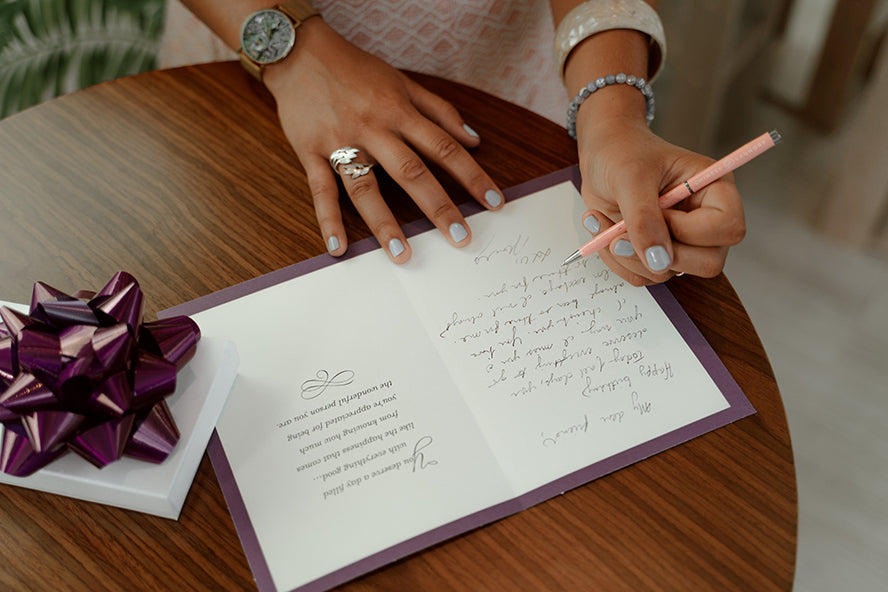 A woman handwriting a card.