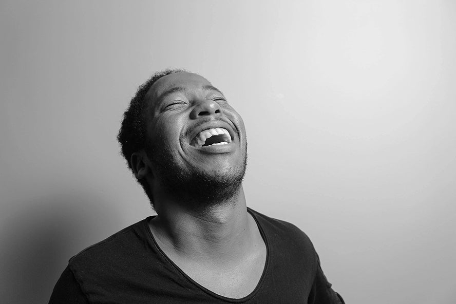 Black and white photo of a man laughing closeup.