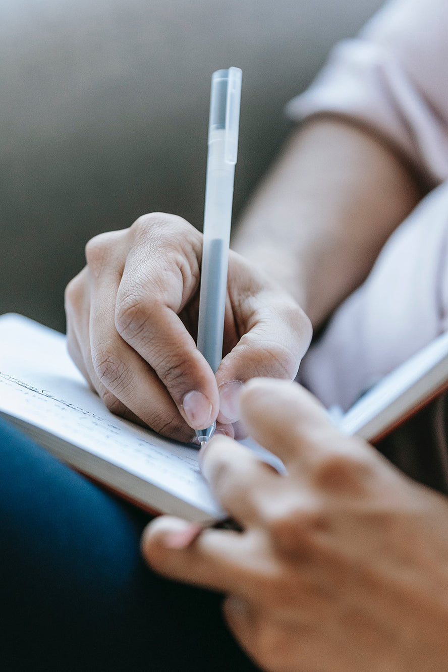 Closeup on someone handwriting in a notebook.