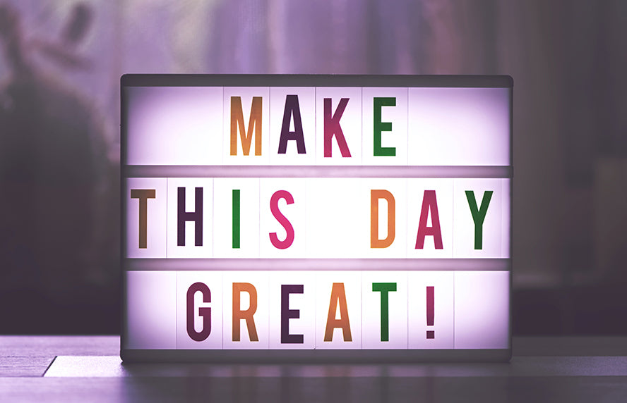 A colorful sign that says "Make this a great day."