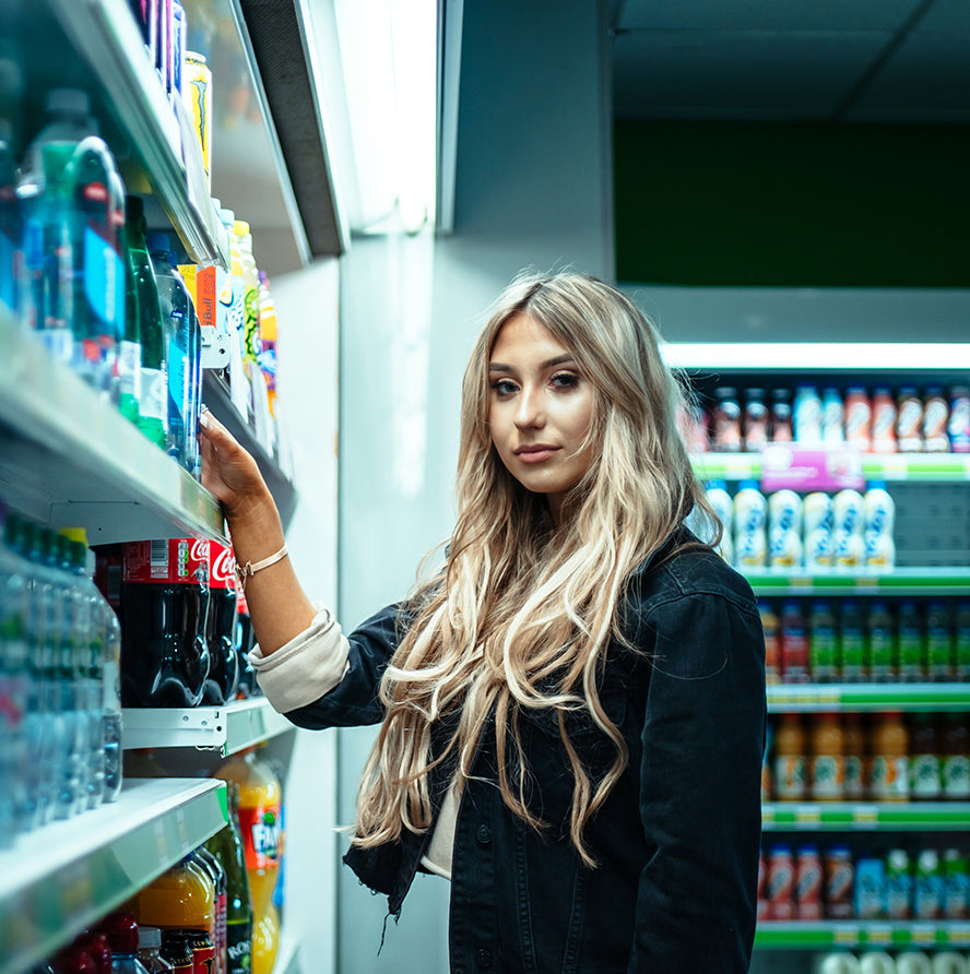 Woman standing in a retail store smiling at the camera.