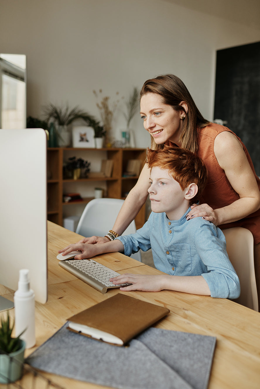 Woman helping her son at the computer.