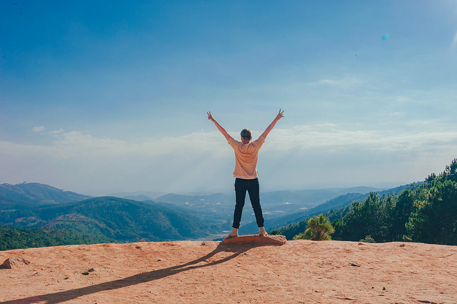 Someone posing proudly after having climbed a mountain.