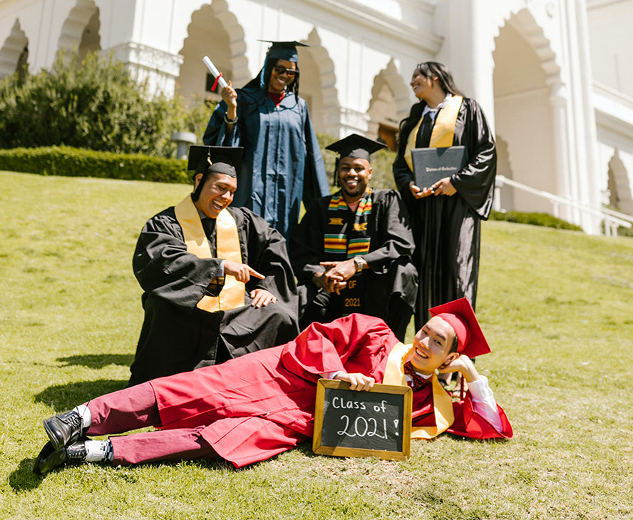 A group of five posing for a fun graduation picture.