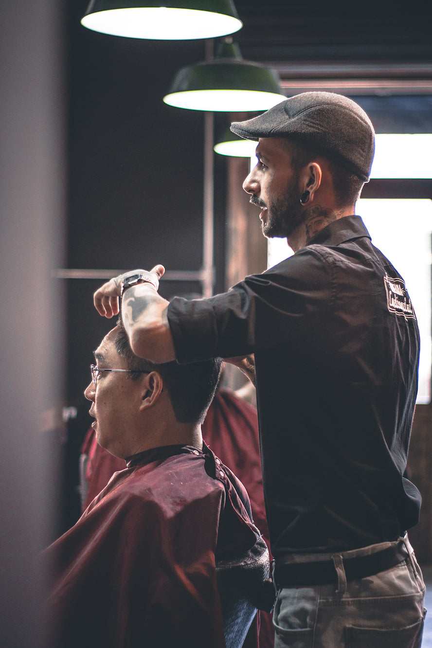A barber listening to his client as he cuts his hair.