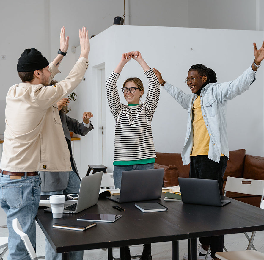 A group of excited coworkers high-fiving.