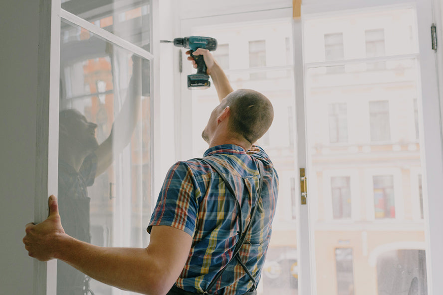 A handyman installing windows.