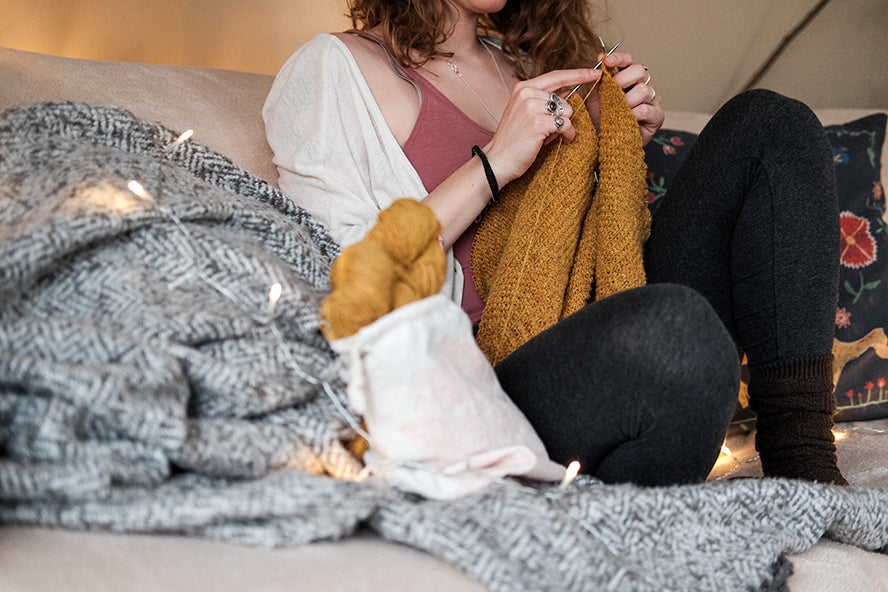 A woman expressing her interests by knitting.