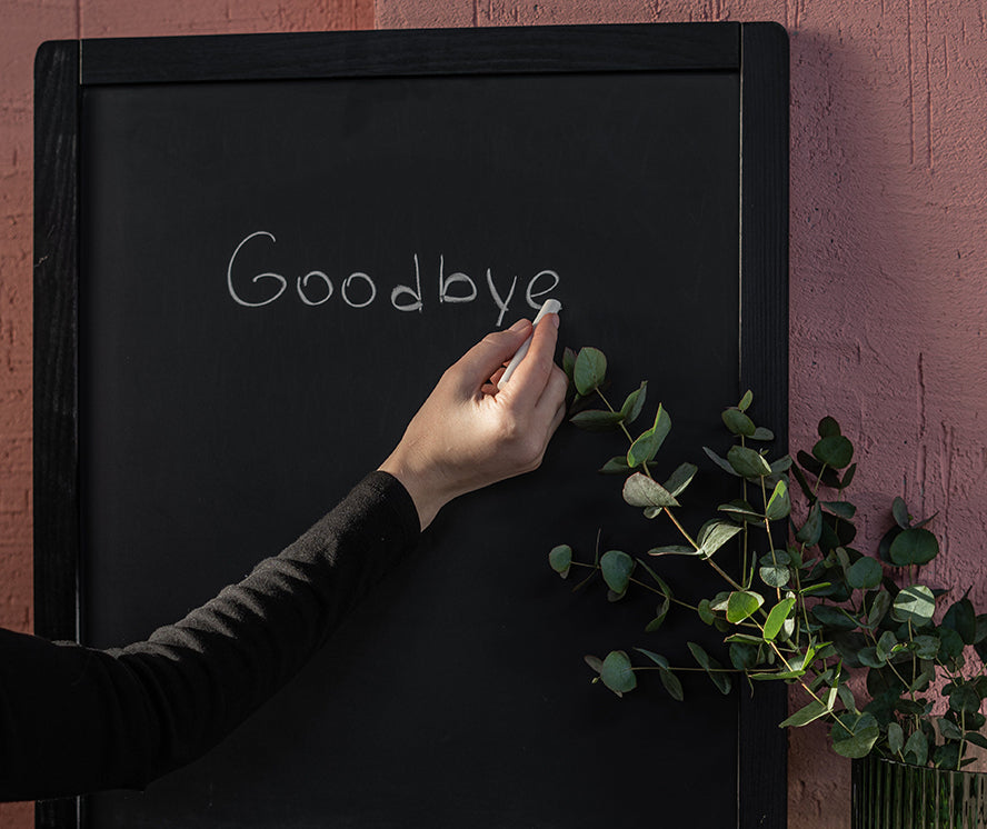 Someone writing "goodbye" on a chalkboard.