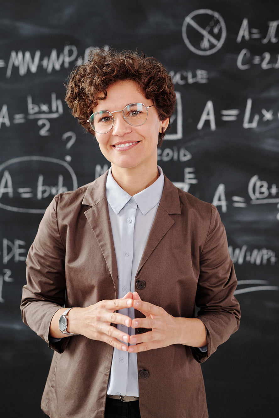 A proud teacher standing at her board.