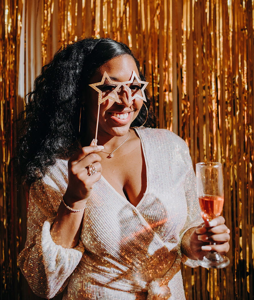 A party guest posing for a photo wearing star-shaped glasses.