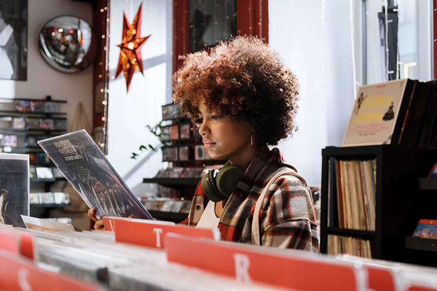 A woman buying a record at a record store.