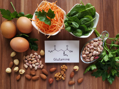 Food rich in glutamine with structural chemical formula of glutamine molecule. Food for training and exercise: spinach, eggs, parsley, carrot, beans, almond, walnut. Bodybuilding, sport nutrition.