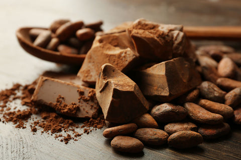 Spoon with aromatic cocoa and chocolate on wooden background, close up