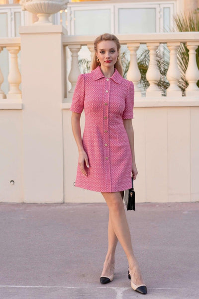 Blonde girl standing near a wall wearing a classic pink tweed Gaâla Barbie-inspired dress
