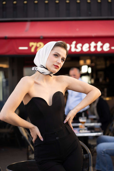 Brunette girl posing by a Parisian cafe in a silk headscarf and Gaâla black corset top.