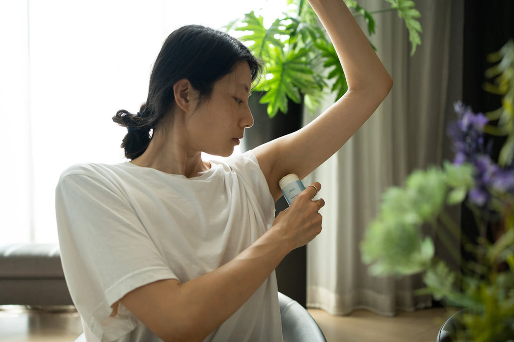 woman applying deodorant under her arm