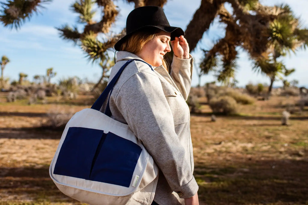 Woman in nature walking with a multi-pocket tote bag on her shoulder