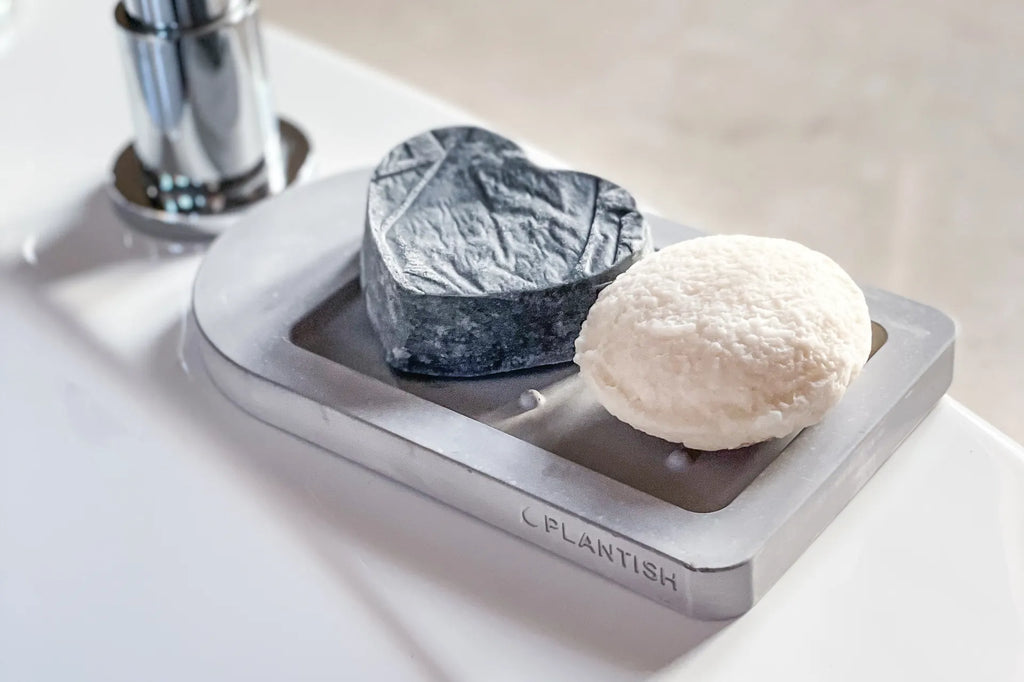 A bars on a diatomite self-drying soap dish on a bathtub ledge