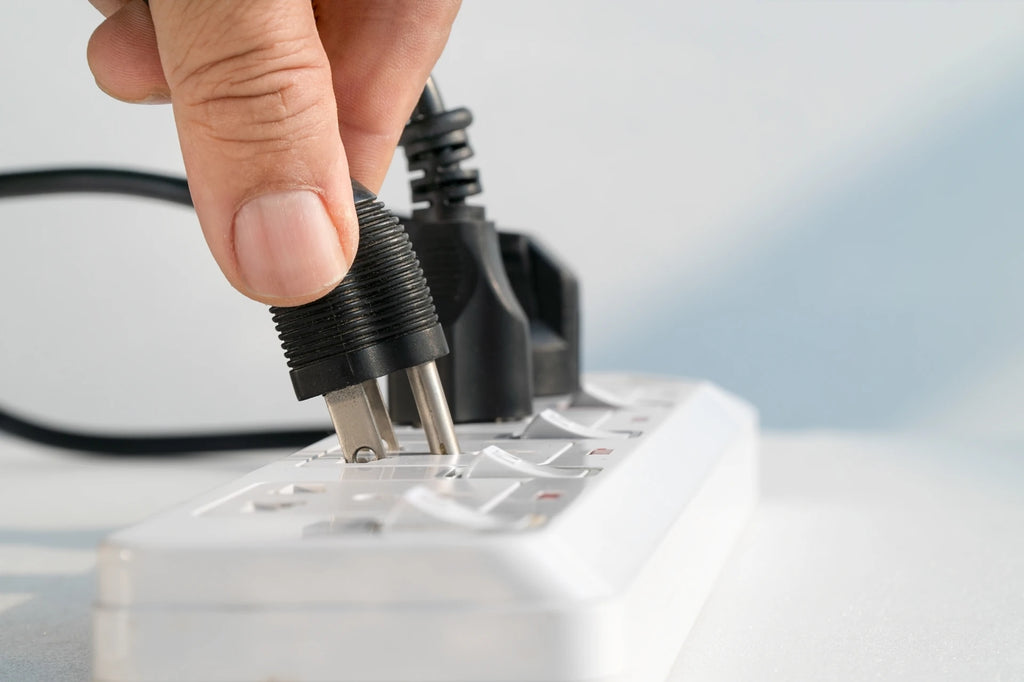 Person plugging in a plug into a power bar