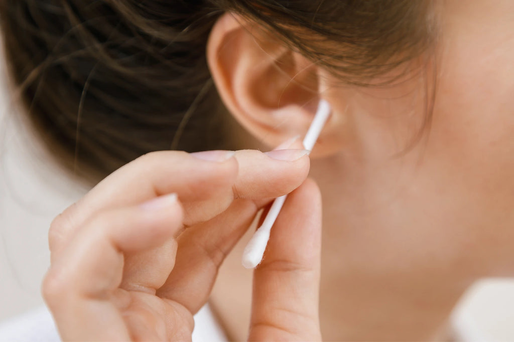 Close up a woman using a qtip cleaning her ear