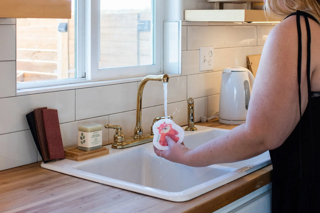 Woman finished popping up her red panda pop up sponge over the kitchen sink