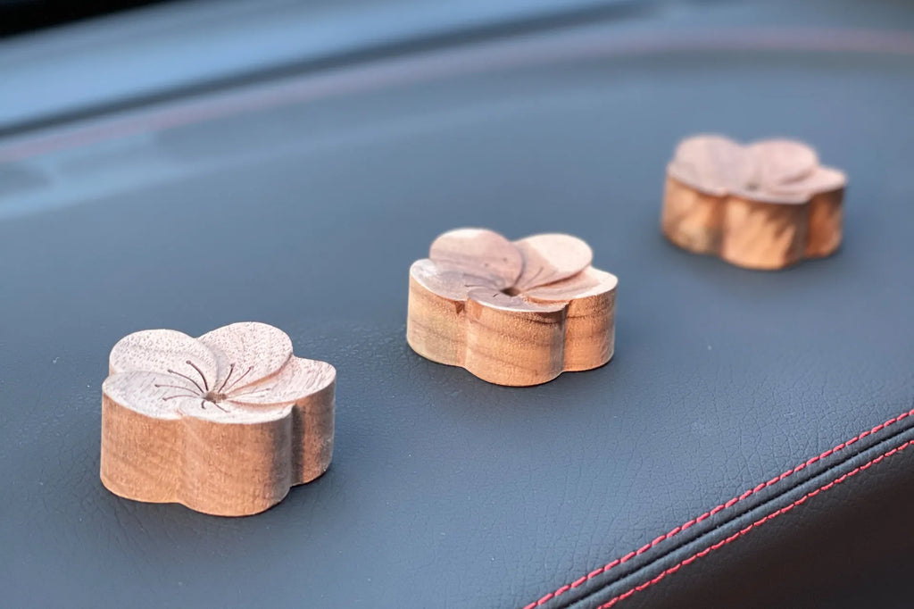 Flower wooden diffusers soaked with essential oils on car dashboard 