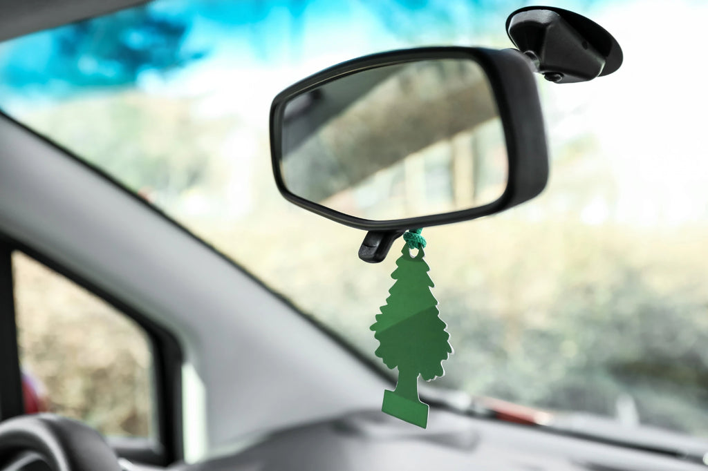 Air freshener tree hanging on car rearview mirror
