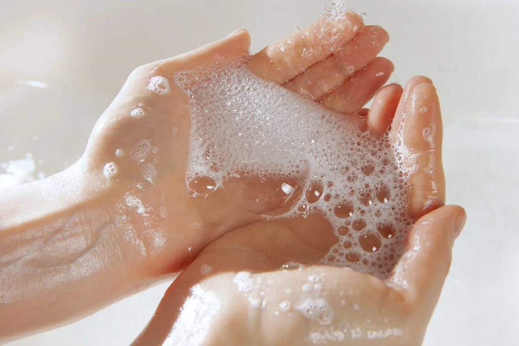 Woman cupping hand full of suds in bathroom